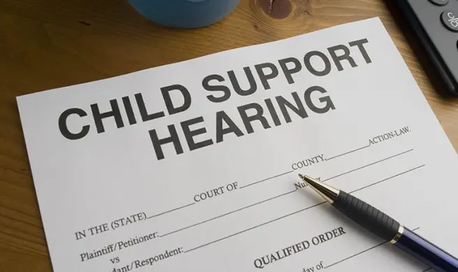 A child support hearing form with pen on top of it.